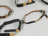 four different types of leather belts with gold buckles on a white surface