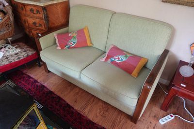 un canapé vert avec des coussins colorés dans un salon