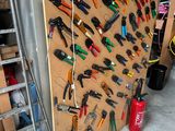 many tools hanging on the wall in the garage