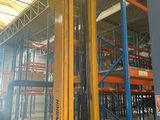 a fork lift in a large warehouse with lots of shelves