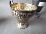 a silver bowl sitting on a table next to a wine bottle