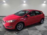 Une Ford Focus rouge est garée sur un sol à damier.