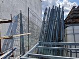 de nombreux tuyaux métalliques et une clôture devant un bâtiment