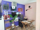 une petite table et des chaises dans une pièce aux murs violets