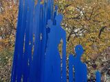 a blue sculpture of a group of people in a park