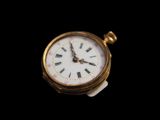 une petite montre de poche en or dont le cadran est orné de chiffres romains