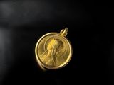 gros plan d'une pièce d'or portant un visage de femme