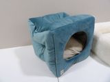 a cat bed that is on a table next to a pillow