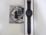 a smart watch sitting in a box next to a charger
