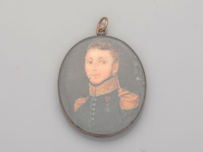 Une vieille photo d'un homme en uniforme militaire est représentée sur un pendentif