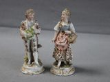 deux figurines représentant une femme et un homme debout l'un à côté de l'autre