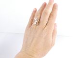 a woman ' s hand holding a ring with a flower on it