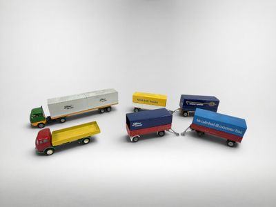 plusieurs camions jouets sont alignés sur une surface blanche