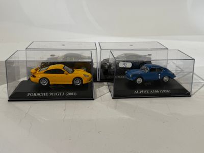 two model cars are in a clear display case on a white surface