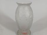 a white vase with a red handle sitting on a white surface