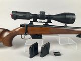 a close up of a rifle with a scope on a white background