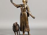 bronze statue of a woman with a dog on a rock