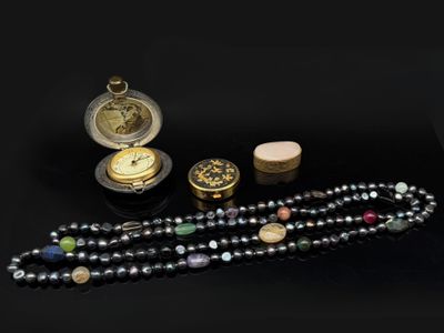 un long collier de perles orné d'une montre de poche