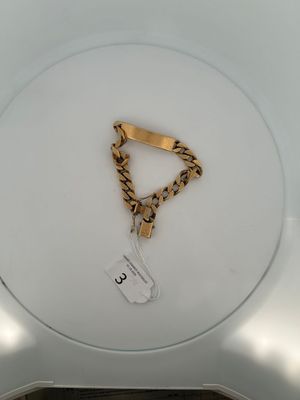 a picture of a white toilet with a gold chain on it
