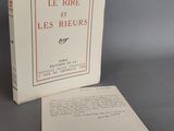 Le livre est ouvert et posé sur la table, à côté d'une feuille de papier.