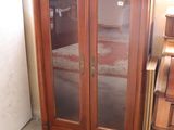 a wooden cabinet with glass doors in a room