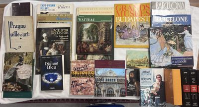 beaucoup de livres posés sur une table, à côté d'un ordinateur portable