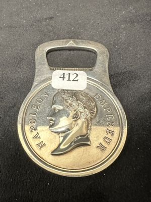 un gros plan d'un décapsuleur sur lequel repose une pièce de monnaie