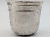 a silver cup sitting on top of a white table