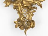 a gold clock that is on the wall of a room