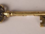 a close up of a golden key on a white surface
