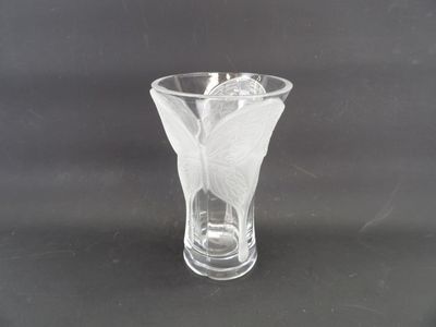 un vase en verre avec une fleur à l'intérieur sur une table