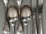 five forks, a spoon, and a knife on a table