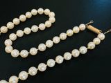 gros plan d'un collier de perles blanches sur une surface noire