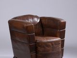 un fauteuil en cuir marron posé sur un sol blanc