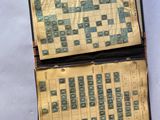 un vieux livre sur lequel figure une partie de Scrabble