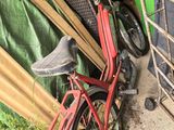 un vélo rouge garé près d'une clôture