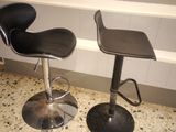 two black stools sitting next to each other on a counter