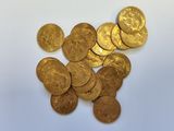 a pile of gold coins on a white surface