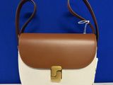 a white and brown handbag sitting on top of a table