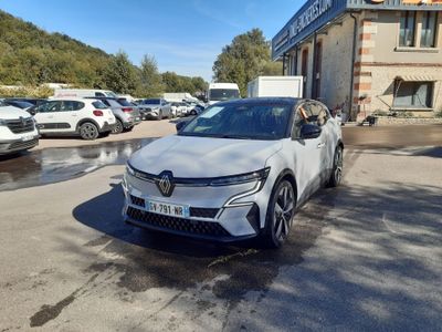 une voiture blanche garée devant un immeuble sur lequel est accrochée une pancarte