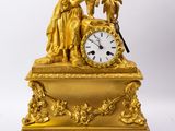 une horloge en or surmontée d'une statue