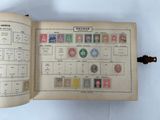 an open book with stamps on it sitting on top of a table