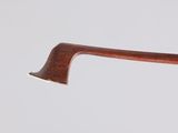 close up of a wooden stick with a bell hanging from it ' s end