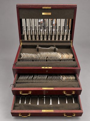 un coffret en bois contenant de l'argenterie, posé sur une surface grise