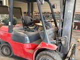 un chariot élévateur rouge garé dans un entrepôt