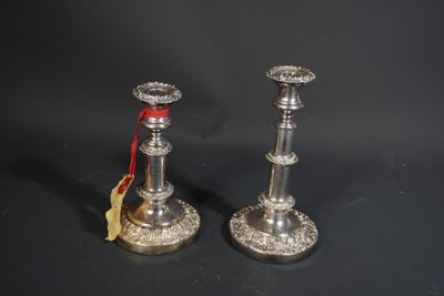 une paire de bougeoirs en argent ornés d'un ruban rouge sur fond noir