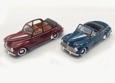 two toy cars sitting next to each other on a white surface