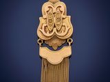a gold pendant with a tassel hanging from it ' s side