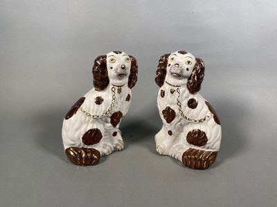 pair of brown and white dog figurines on grey background