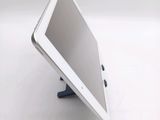 a tablet computer sitting on a stand on a white surface